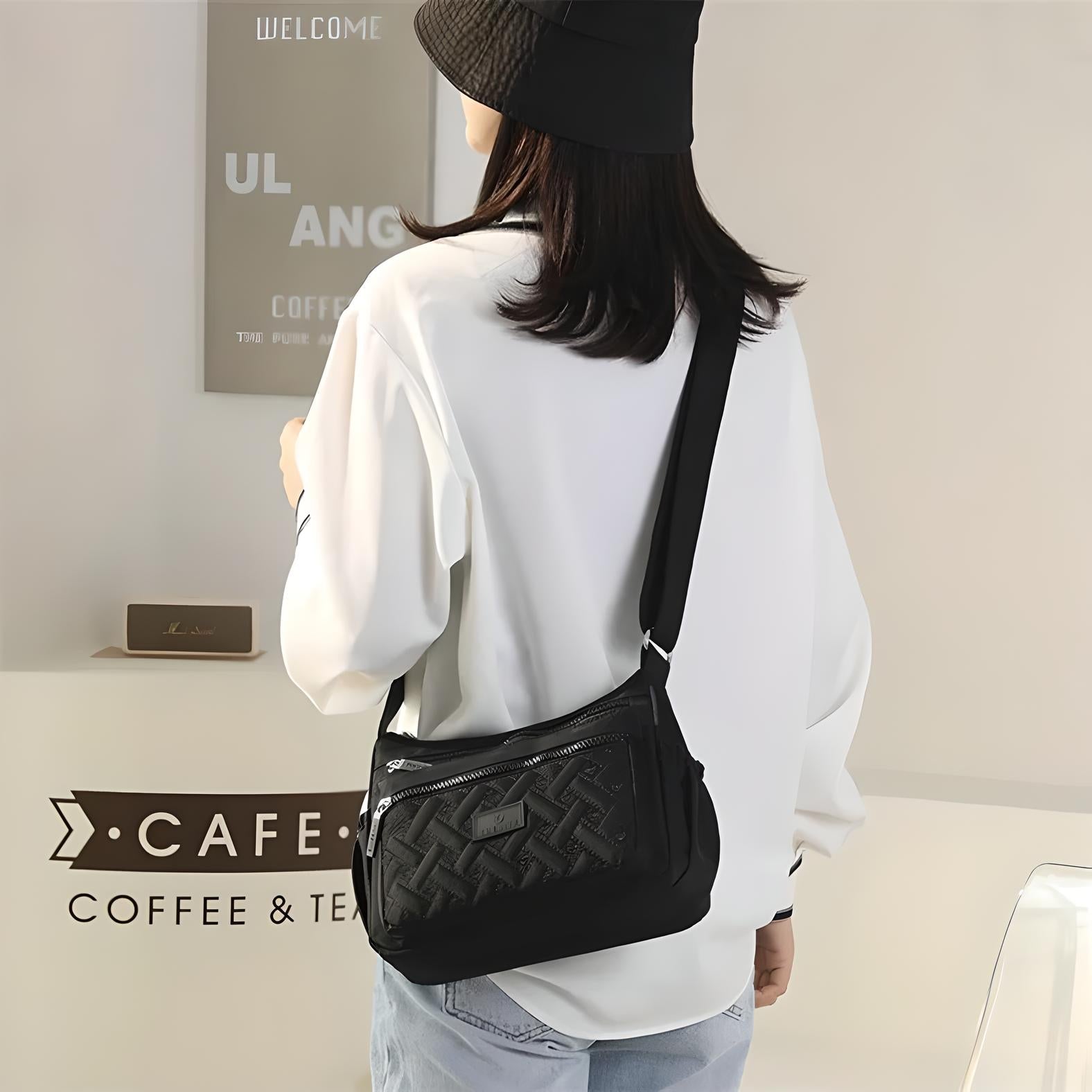 Frau mit schwarzer Umhängetasche, weißem Hemd und Hut in modernem Café.