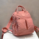 Rosa Rucksack mit mehreren Taschen, Reißverschlüssen, robustem Stoff, ideal für Schule oder Reisen.