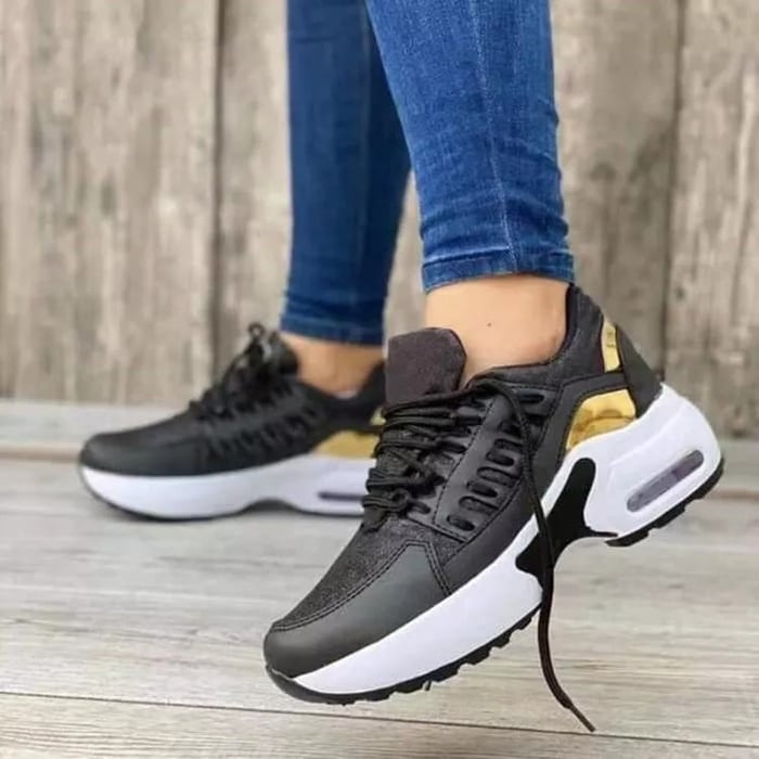 Schwarze Sneaker mit goldenen Akzenten und weißer Sohle, ideal für Damenmode. Bequeme Sportschuhe, perfekt für Freizeit und Fitness.