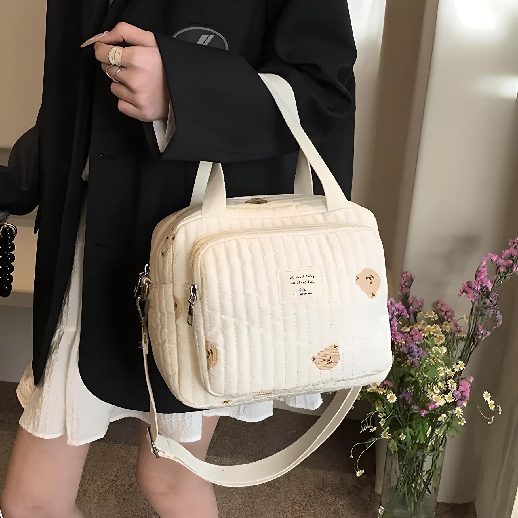 Beige Umhängetasche mit Bärenmotiv, gesteppt, Damenmode, Freizeit, Blumenhintergrund.