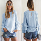 Damenbluse mit Rüschenärmeln in Hellblau, kombiniert mit zerrissenen Jeansshorts. Modetrend, lässiger Sommerlook, stilvolle Freizeitkleidung.