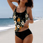 Frau am Strand in einem schwarzen Tankini mit Blumenmuster, ideal für Sommermode. Perfekt für Strandurlaub und Bademode-Trends 2023.