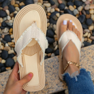 Beige Damen-Sandalen mit geflochtenem Riemen, ideal für Sommer und Strand. Komfortable Flip-Flops auf Kieselsteinen. Perfekt für Freizeitmode.