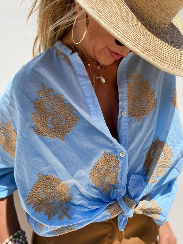 Frau mit blauem Hemd, goldene Stickerei, Strohhut, Sommermode, eleganter Look.