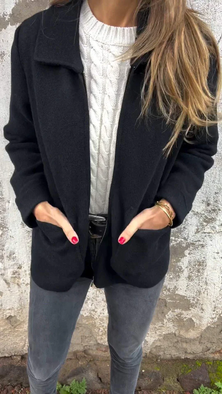 Damenmode: Eleganter schwarzer Mantel, kombiniert mit weißem Strickpullover und grauer Jeans. Perfekt für stilvolle Herbst- und Winteroutfits.