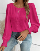 Damenbluse in leuchtendem Pink mit langen Ärmeln und strukturiertem Muster, kombiniert mit Jeans. Perfekt für modische Freizeitlooks.