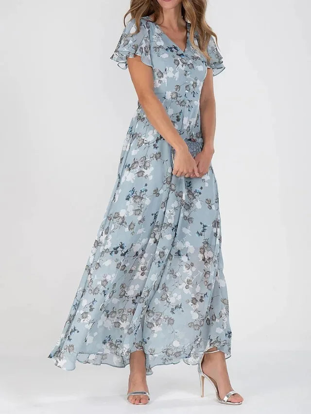 Frau in langem, blauem Blumenkleid aus Chiffon, elegante Mode, Sommerkleid, hohe Absätze.