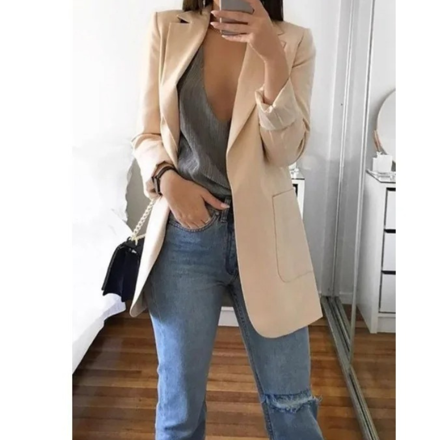 Damenmode: Eleganter beiger Blazer kombiniert mit grauem Top und blauen Jeans. Perfekt für stilvolle Freizeit- und Business-Looks.