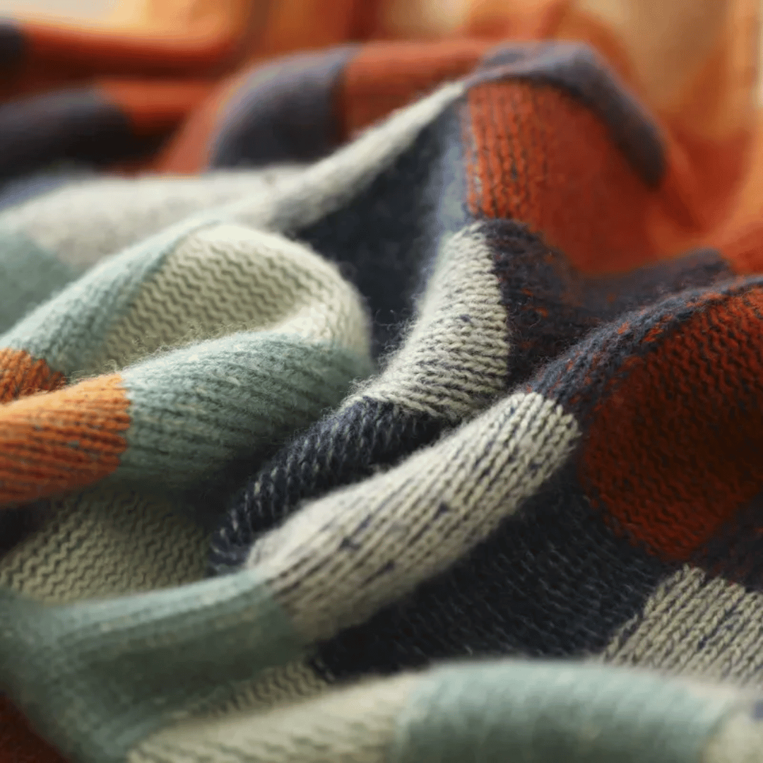 Bunte gestrickte Decke aus weicher Wolle, ideal für gemütliche Abende. Hochwertige Strickware, warm und stilvoll, perfekt für Wohnaccessoires.