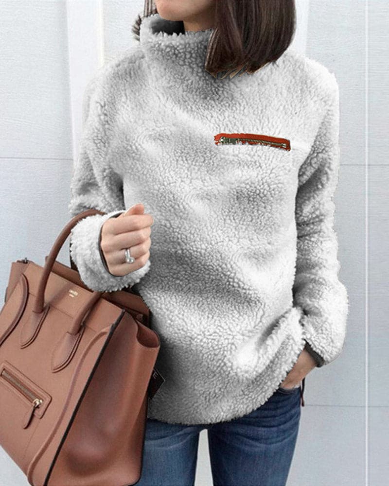 Damen Teddy-Fleece-Pullover in Grau, kuschelig und warm, ideal für Herbst und Winter. Modischer Look mit brauner Handtasche.