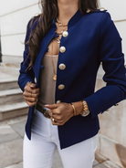 Eleganter blauer Blazer mit goldenen Knöpfen, kombiniert mit weißer Hose und goldenen Accessoires. Perfekt für stilvolle Damenmode.