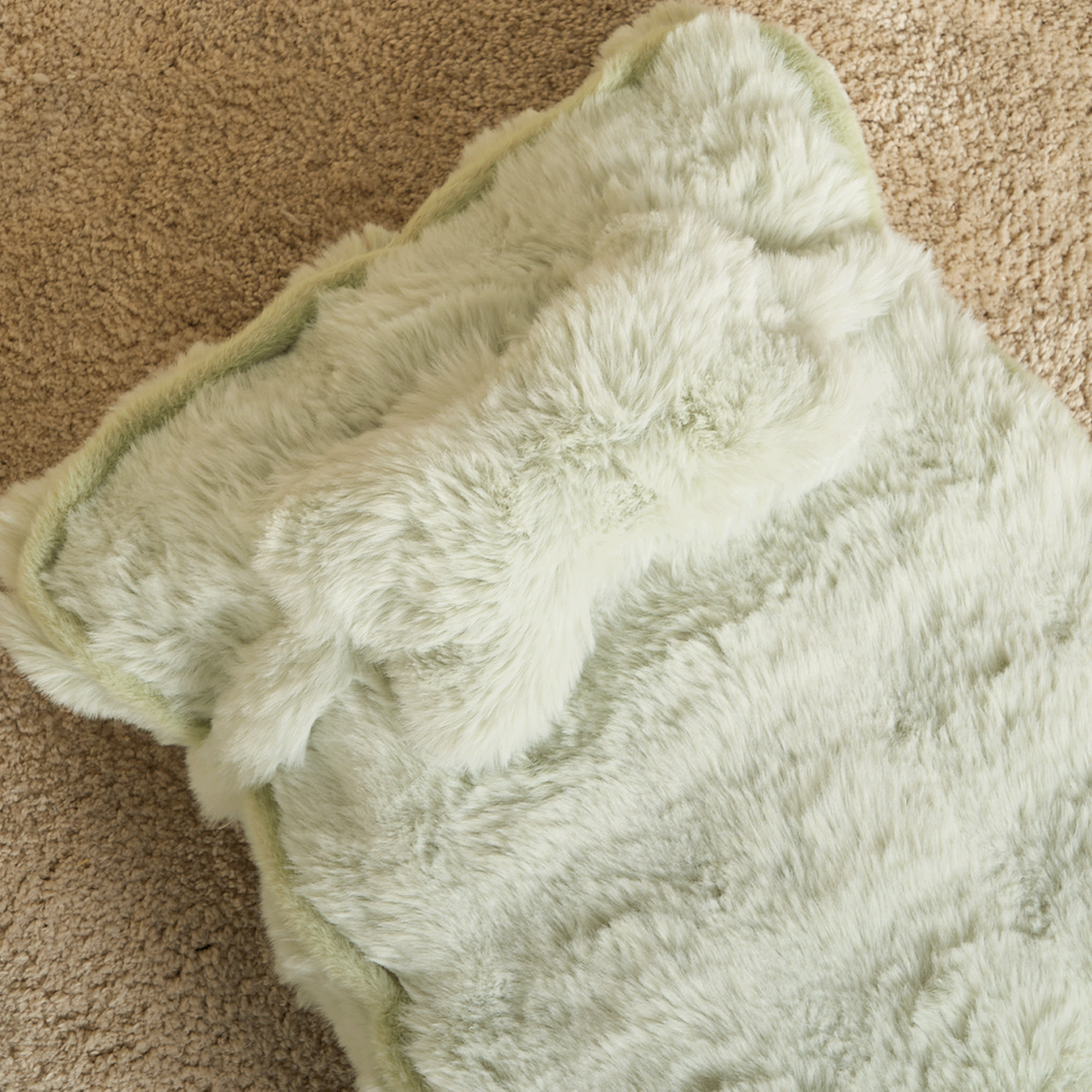 Flauschiges, beruhigendes Kissen in Cremefarbe auf Teppich, ideal für Entspannung und Komfort.