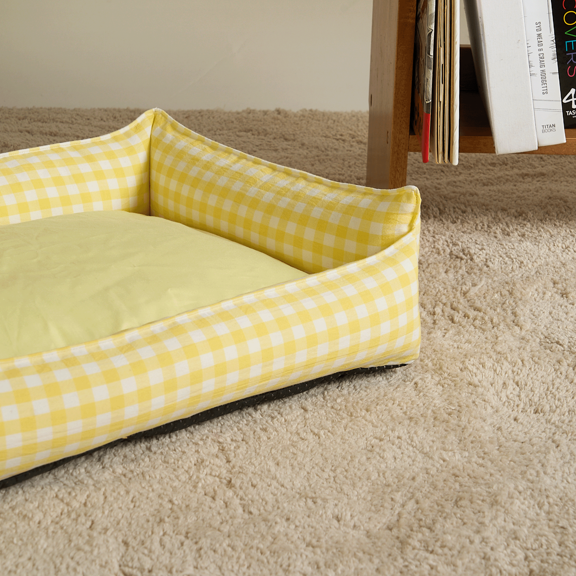 Gelbes kariertes Hundebett, abnehmbar, gemütlich, auf Teppich, modernes Design.