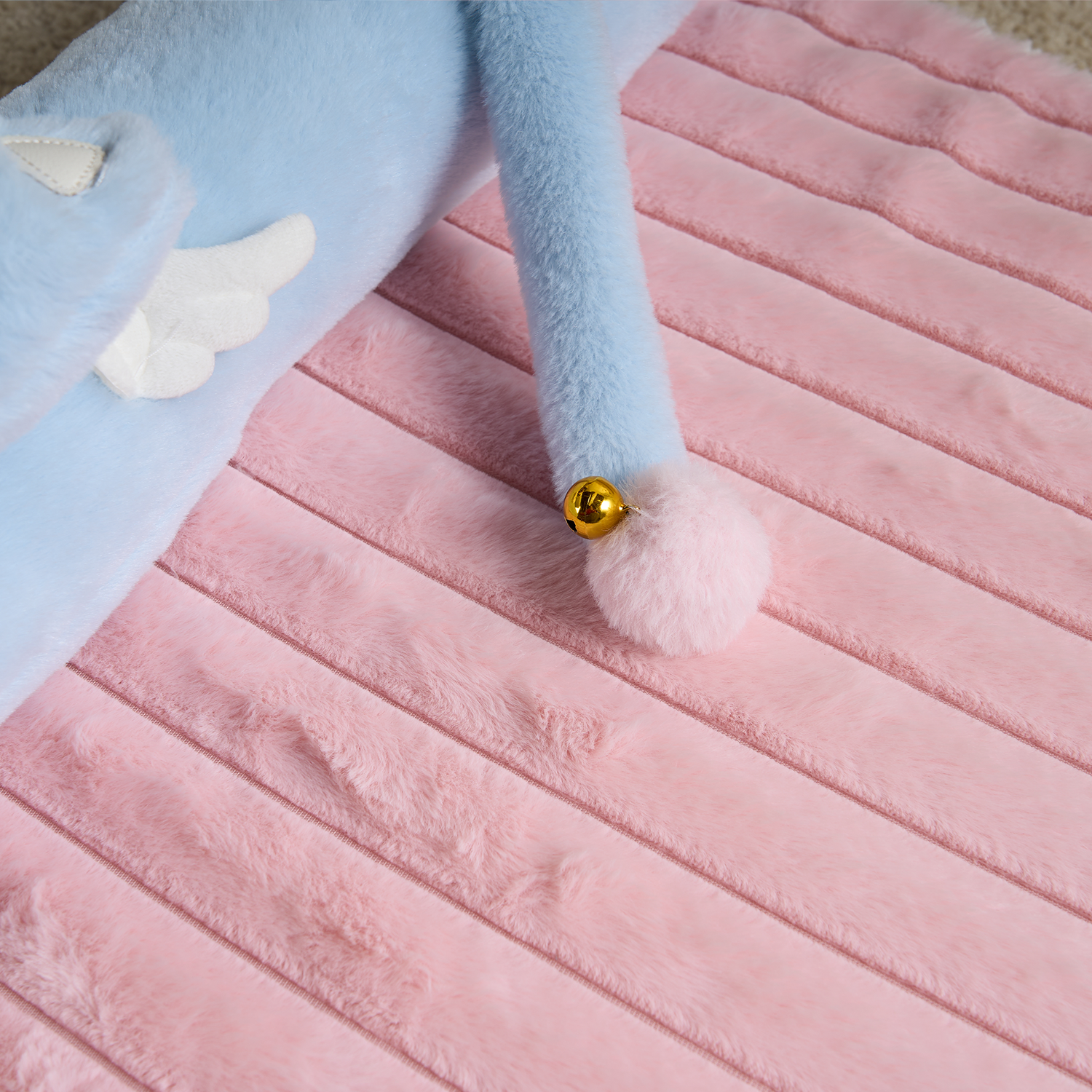 Interaktives Katzenbett aus rosa Plüsch mit blauen Details und Glöckchen, gemütlich und weich.