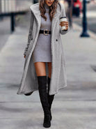 Damenmode: Eleganter grauer Teddy-Mantel, kombiniert mit Strickkleid und schwarzen Overknee-Stiefeln. Perfekt für stilvolle Herbst- und Winterlooks.