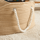 Handgefertigtes Korb-Haustierbett aus Rattan mit Seilgriffen auf Teppichboden.