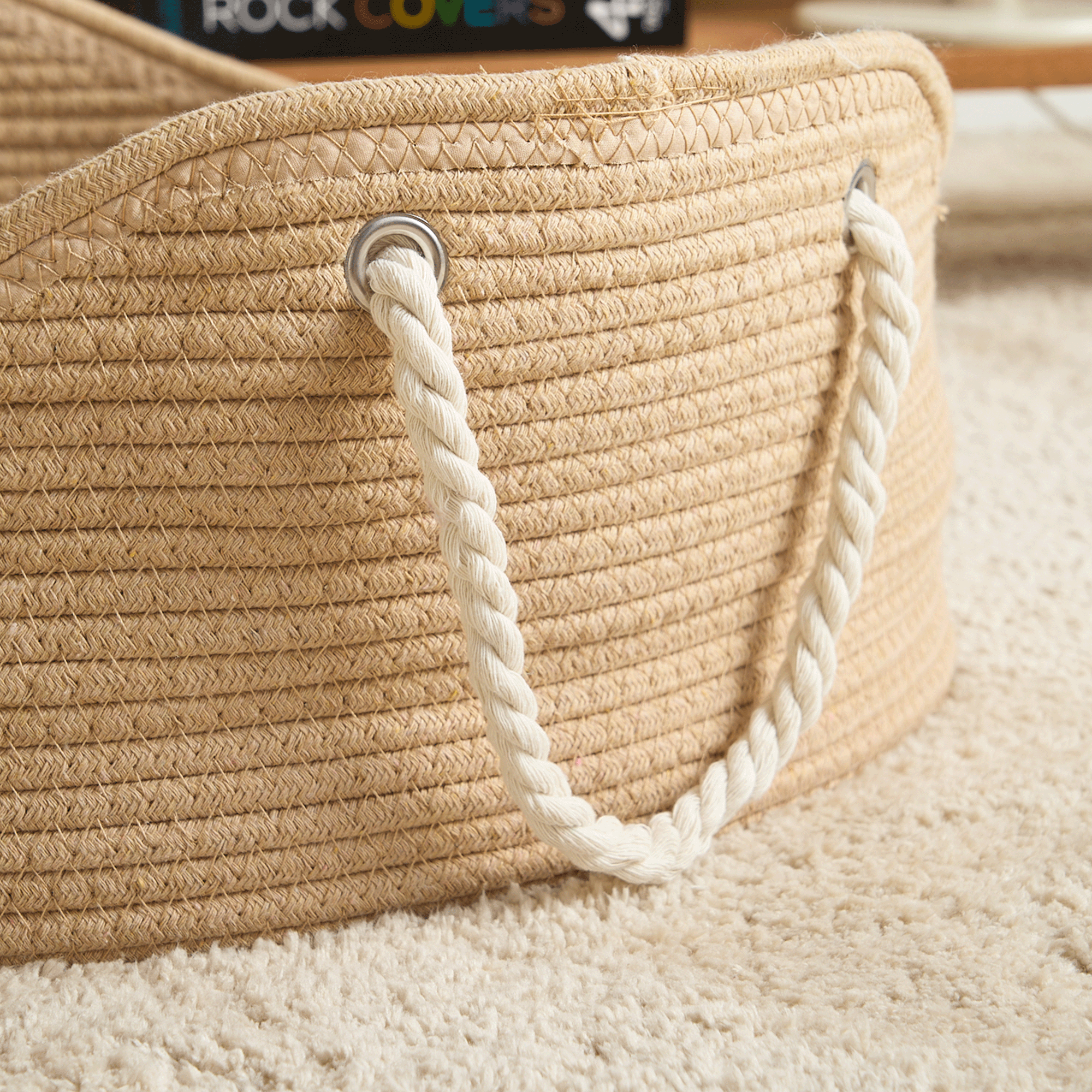Handgefertigtes Korb-Haustierbett aus Rattan mit Seilgriffen auf Teppichboden.