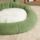 Grünes Haustierbett aus Plüsch, rund, gemütlich, ideal für Hunde und Katzen, auf Teppichboden.