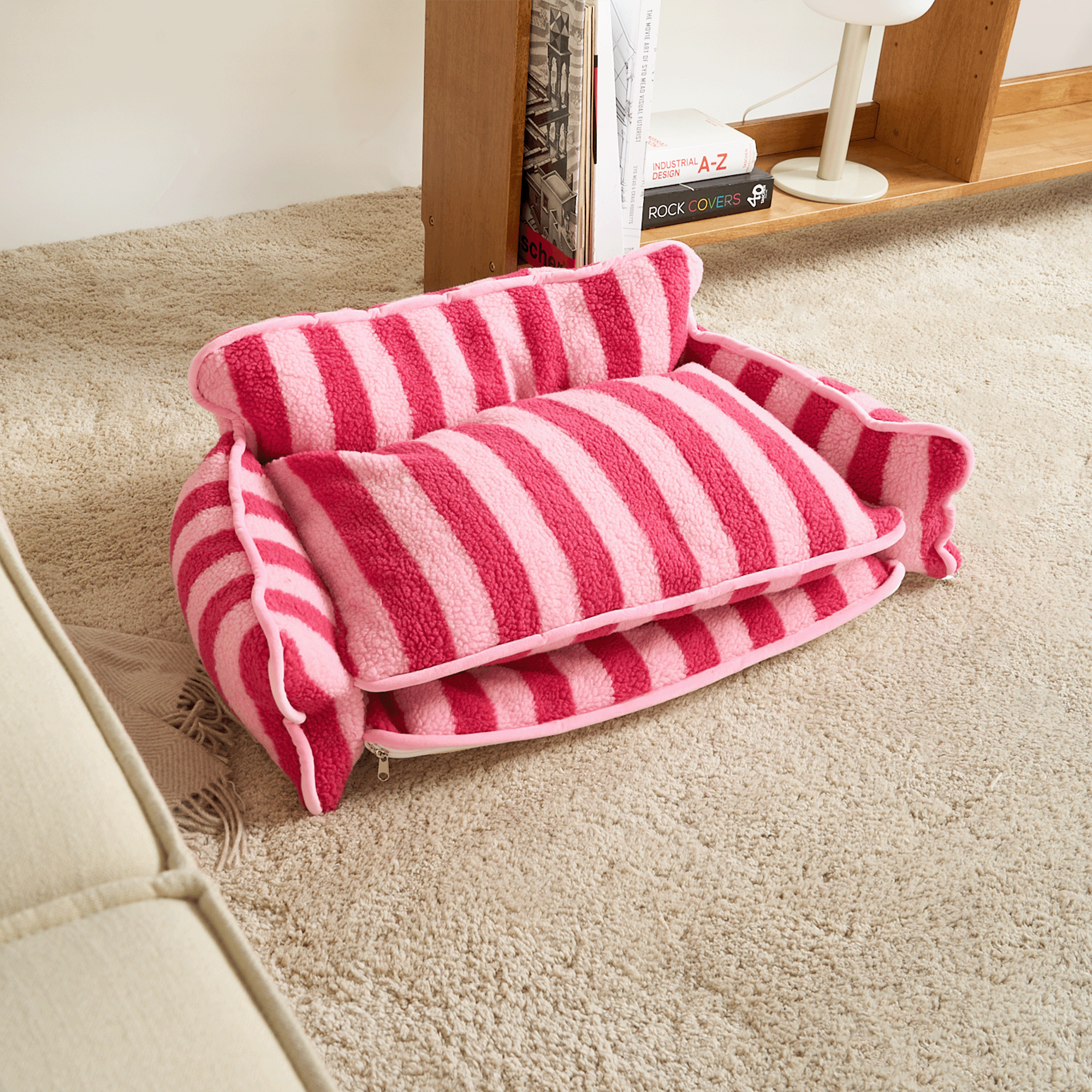 Rosa-gestreiftes Katzen-Sofa aus Lammwolle auf Teppich, gemütliches Haustierbett.