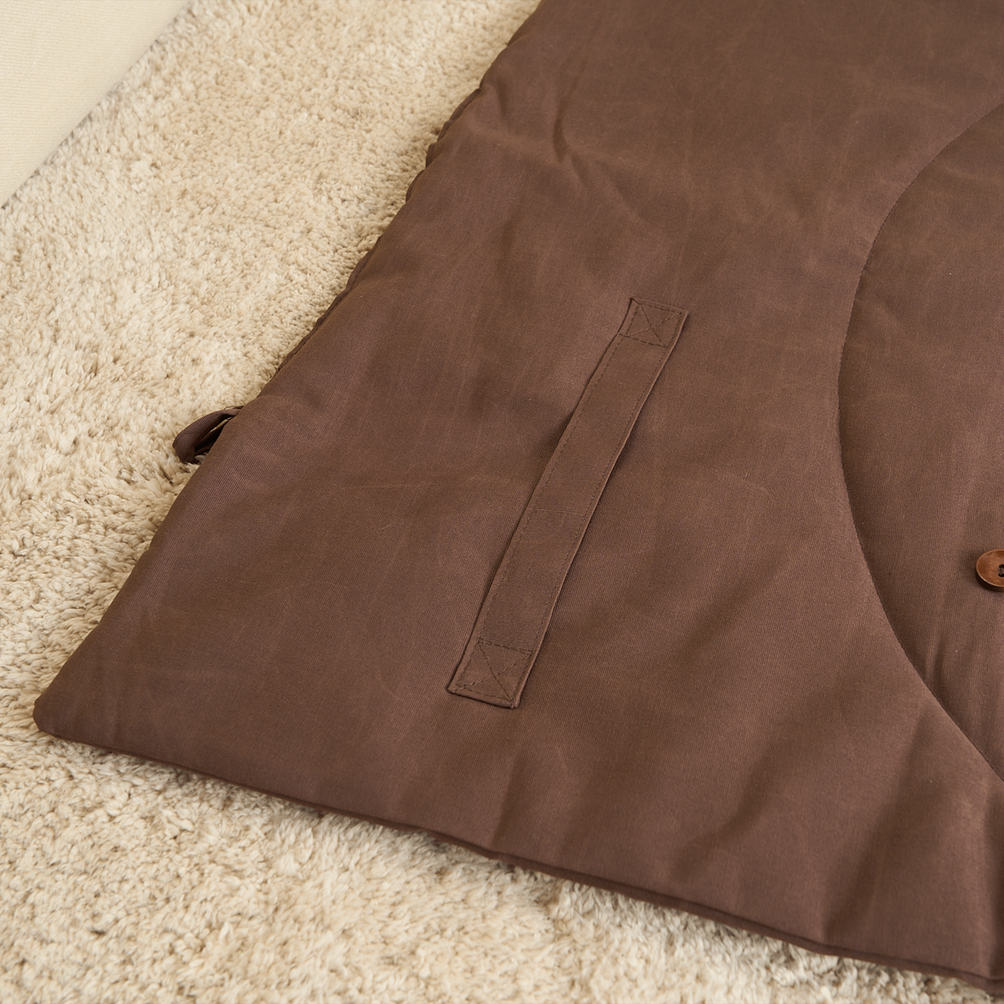 Braune Nomad Haustiermatte auf beigem Teppich, strapazierfähiges Material, ideal für Reisen.