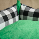 Schwarz-weiß kariertes Katzenbett mit grünem Plüsch, gemütlich und interaktiv.