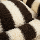 Plüschiges Streifen-Haustiersofa mit Kissen, braun-weiß, gemütlich, modernes Design.