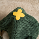 Grünes Katzenbett aus Plüsch mit gelbem Blüten-Design, gemütlich und stilvoll für Haustiere.