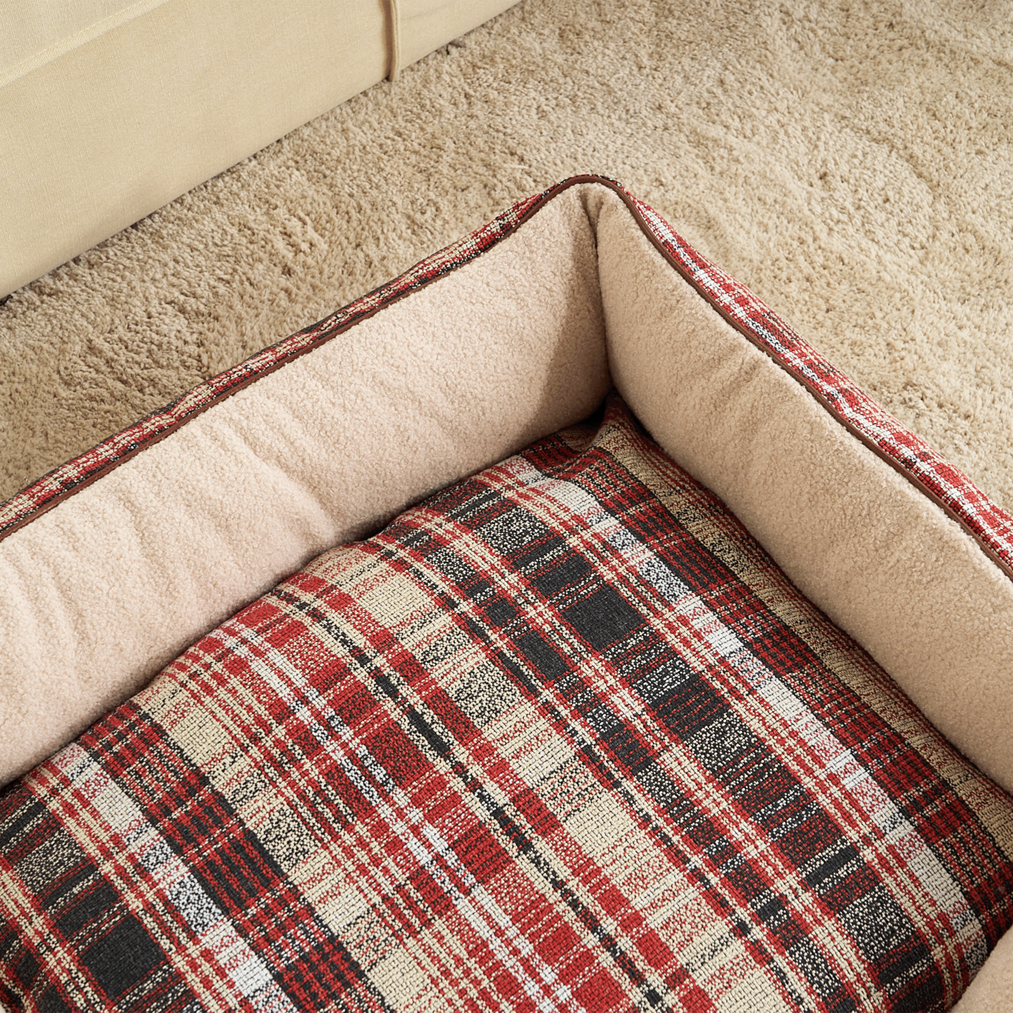 Kariertes Hundebett aus Wolle, rot-schwarz, rustikales Design, gemütlich, auf Teppichboden.