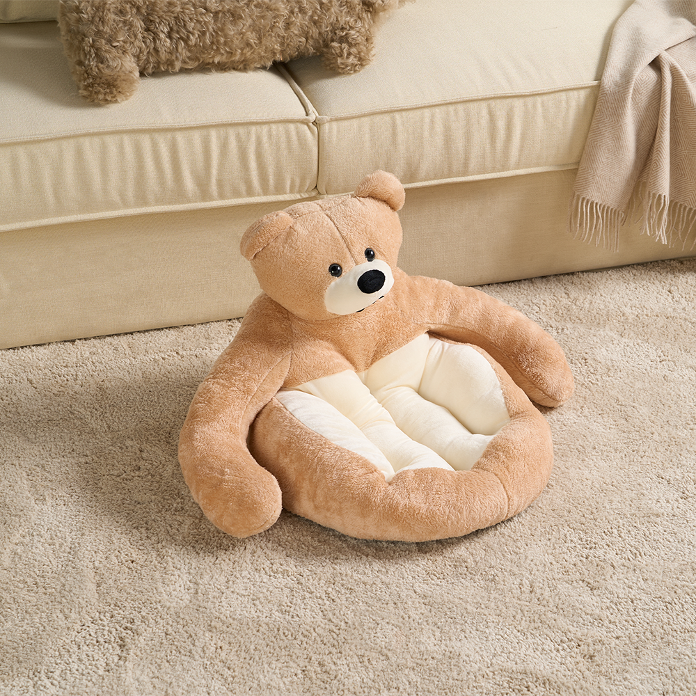 Kuscheliges Bären-Katzenbett aus Plüsch, beige, auf Teppich vor Sofa, Haustierbett für Katzen.