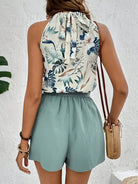 Damen Sommeroutfit, ärmellose Bluse mit Blumenmuster, grüne Shorts, Strohtasche.