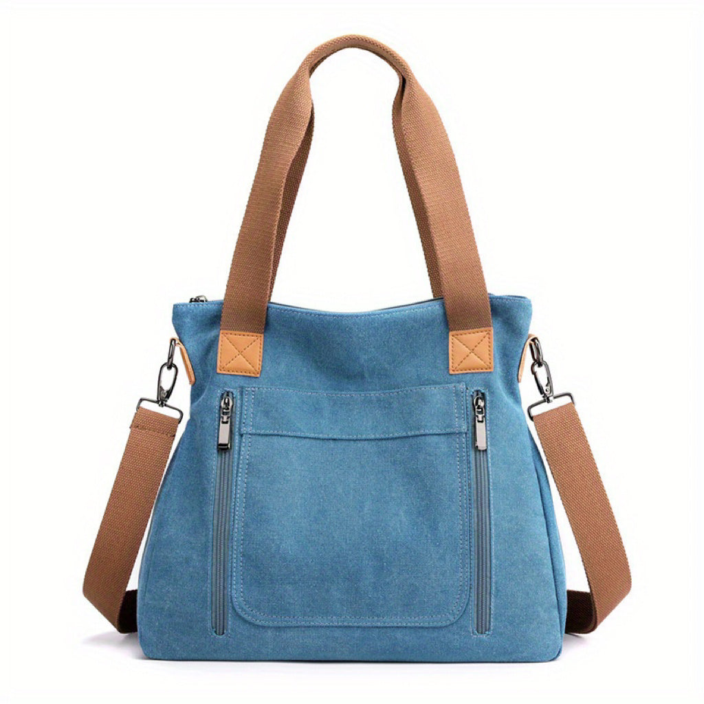 Blaue Canvas-Tasche mit braunen Trägern, Reißverschlusstaschen und abnehmbarem Schultergurt. Stilvolle Damenhandtasche, ideal für den Alltag.