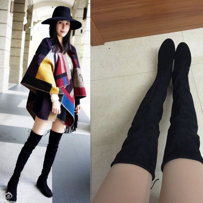 Damenmode: Schwarze Overknee-Stiefel aus Wildleder, kombiniert mit einem eleganten Poncho und Hut. Trendige Herbst- und Winterbekleidung.