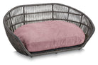 Graues Rattan-Hundebett mit rosa Kissen, stilvolles Haustiermöbel für Innenräume.
