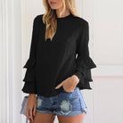 Damenmode: Schwarze Bluse mit Rüschenärmeln, kombiniert mit zerrissenen Jeansshorts. Trendige Freizeitkleidung für stilvolle Outfits.