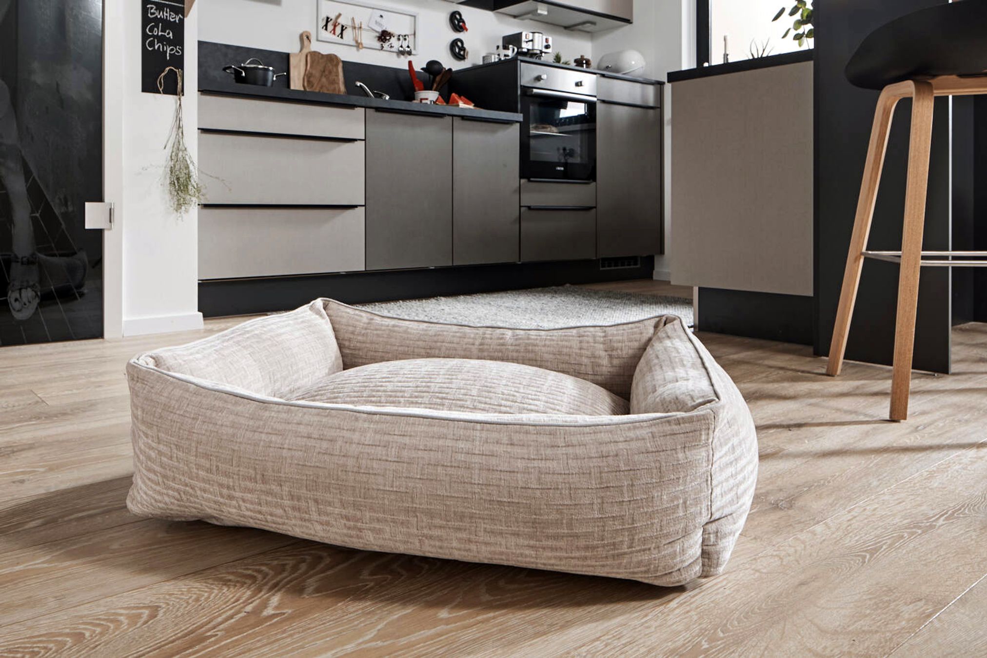 Beiges Hundebett im modernen Wohnzimmer, rechteckig, gemütlich, auf Holzboden.