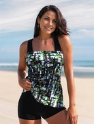 Frau in modischem Tankini am Strand, geometrisches Muster, sommerlich, stilvoll, Badebekleidung, Strandmode, Damenmode, Urlaub, Meer.