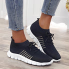 Damen Sneaker in Schwarz mit weißer Sohle, atmungsaktivem Mesh-Obermaterial und Schnürung, ideal für Sport und Freizeit.