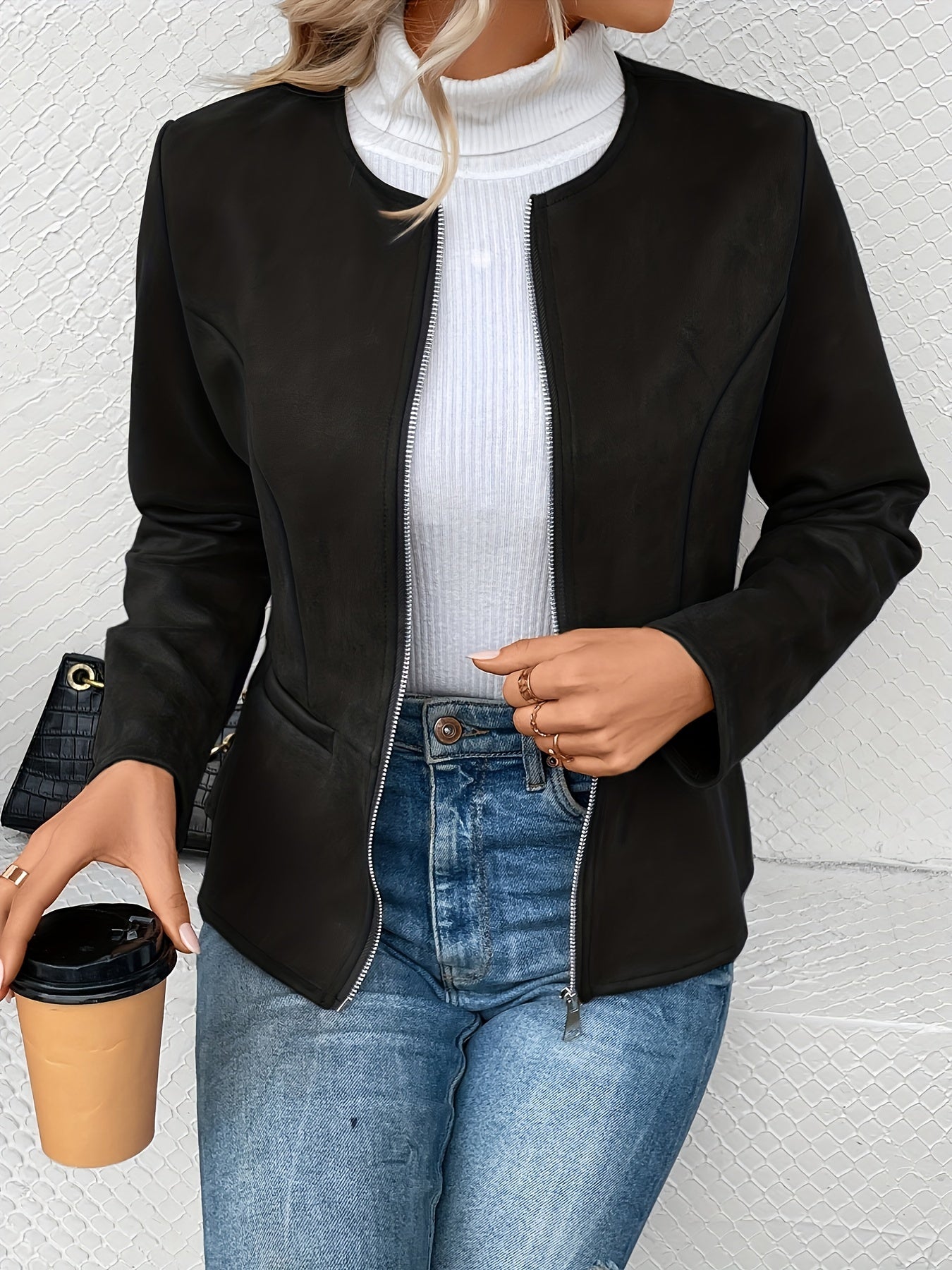 Damen-Lederjacke in Schwarz, kombiniert mit weißem Rollkragenpullover und blauer Jeans. Perfekt für stilvolle Herbst- und Winteroutfits.