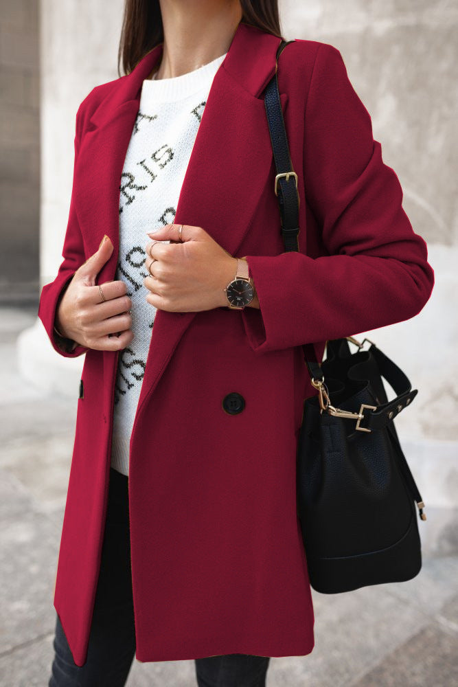 Frau im eleganten roten Mantel, trägt weiße Strickjacke und schwarze Tasche. Modetrend Herbst, stilvolle Damenbekleidung, urbane Eleganz.