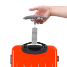 Hand hält tragbare Kofferwaage über rotem Hartschalenkoffer, Reisegepäck, Gewichtsmessung.