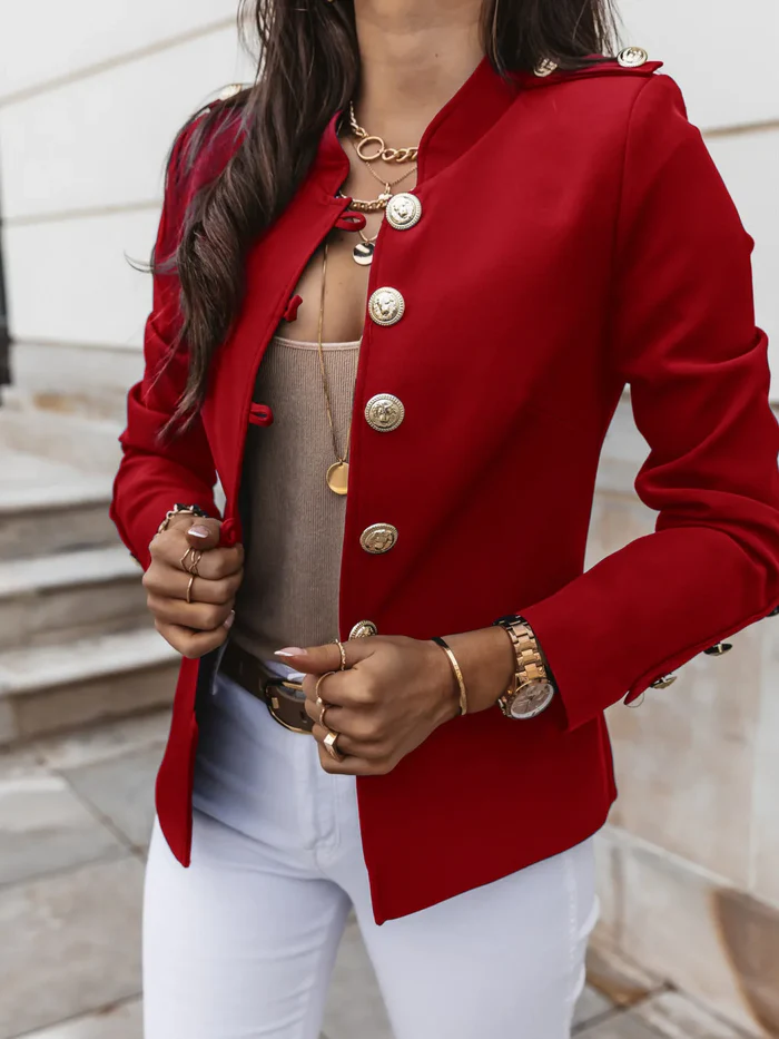 Eleganter roter Blazer mit goldenen Knöpfen, kombiniert mit weißer Hose und goldenen Accessoires. Perfekt für stilvolle Damenmode und Business-Looks.