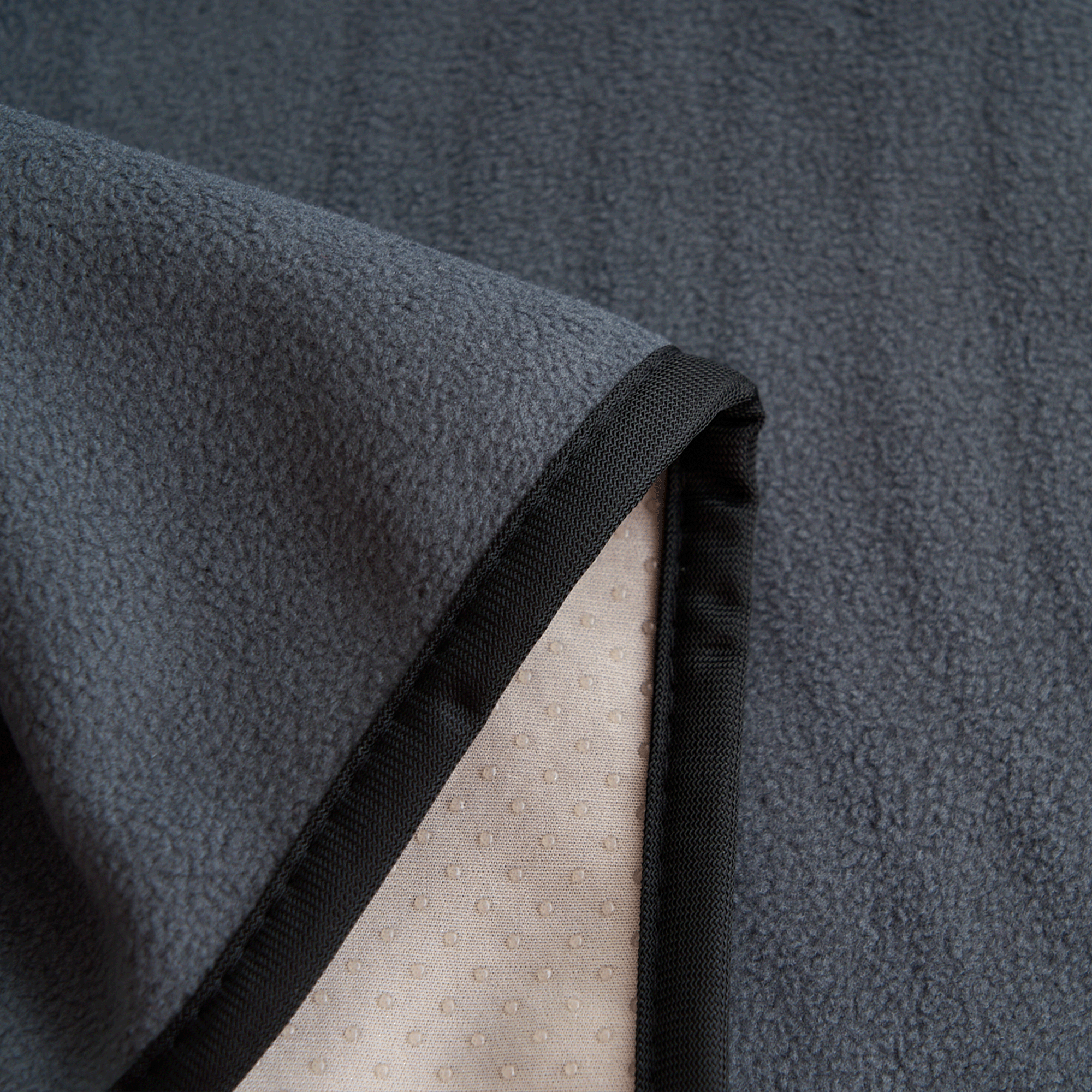 Graue, saugfähige Haustierunterlage aus Fleece mit rutschfester Unterseite, ideal für Hunde.