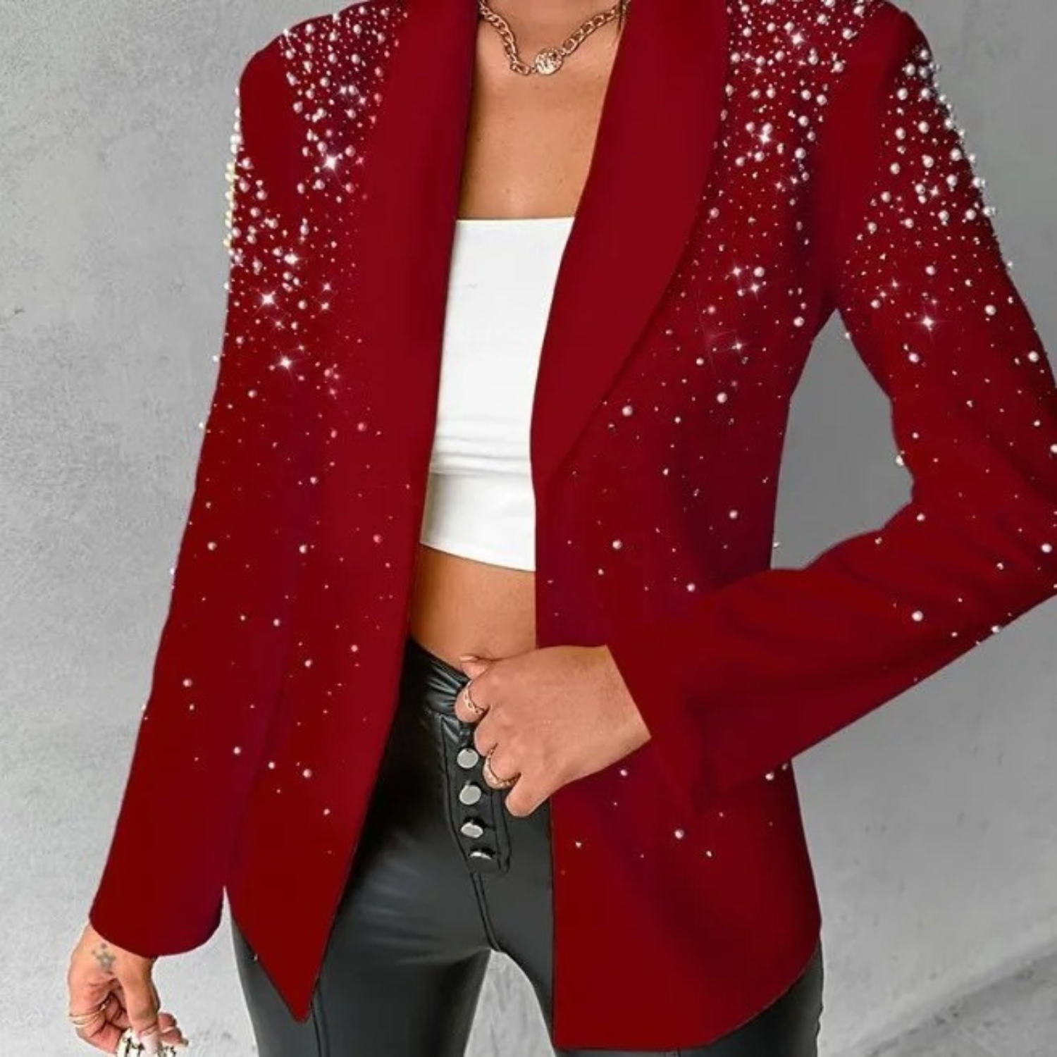 Eleganter roter Blazer mit funkelnden Pailletten, kombiniert mit einem weißen Crop-Top und schwarzen Lederhosen. Perfekt für festliche Anlässe.