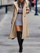Damenmode: Langer, beiger Teddy-Mantel über grauem Strickkleid, kombiniert mit schwarzen Overknee-Stiefeln. Trendiger Herbst-Look.