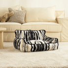 Zebra-Muster Haustiersofa vor beigem Sofa, luxuriöses Design, gemütlich, Wohnzimmer-Dekor.