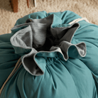 Türkises, weiches Hundebett mit grauem Innenfutter, ideal für Haustiere, gemütlich und stilvoll.