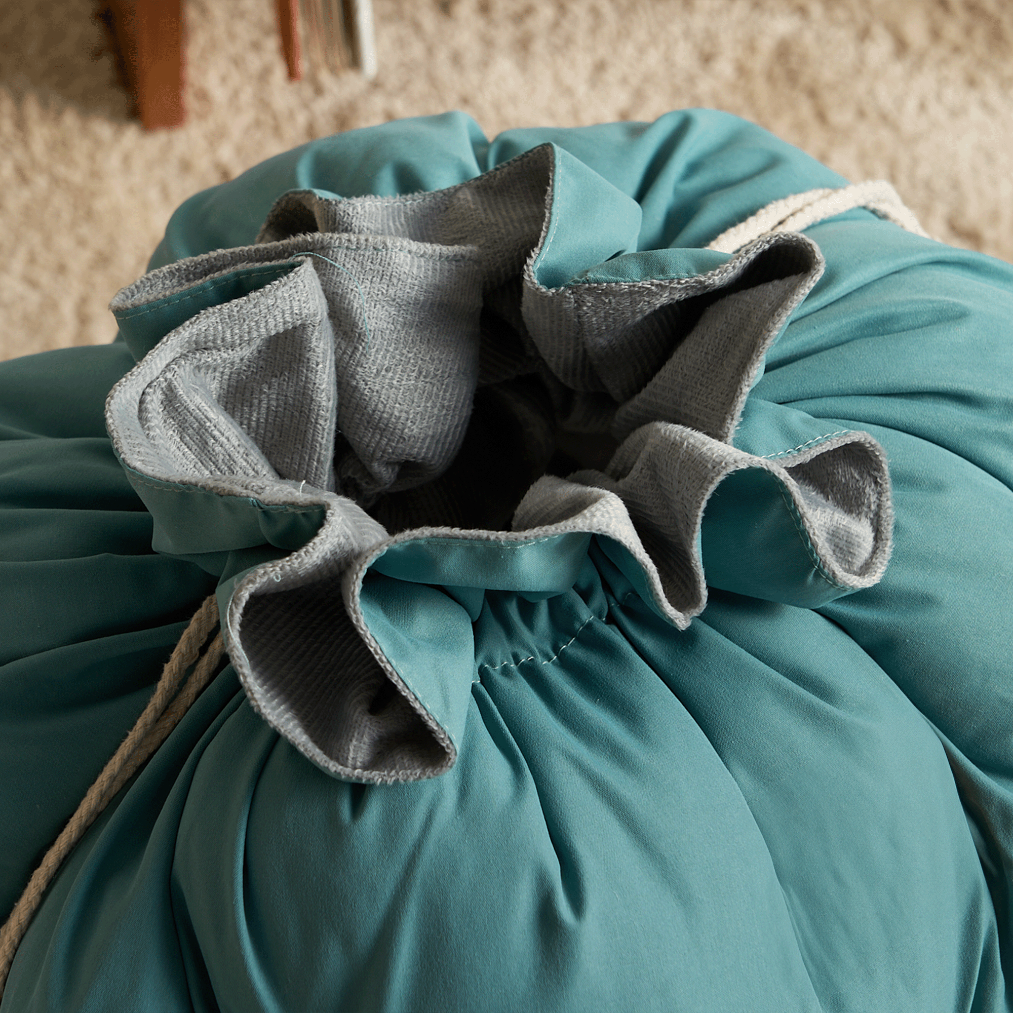 Türkises, weiches Hundebett mit grauem Innenfutter, ideal für Haustiere, gemütlich und stilvoll.