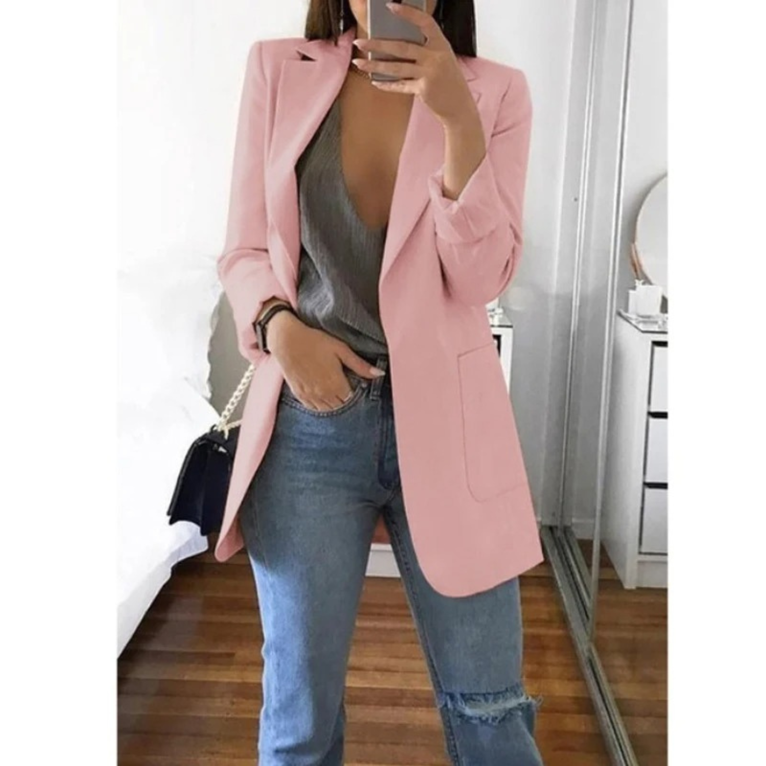 Damenmode: Eleganter rosa Blazer kombiniert mit grauem Top und blauen Jeans. Perfekt für stilvolle Freizeit- und Büro-Outfits.