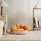 Katzenhöhle aus Plüsch in Orange, gemütlich, rund, auf Teppich im Wohnzimmer, modernes Design.
