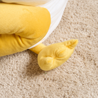 Gelbes Enten-Katzenbett aus Plüsch auf Teppich, gemütlich und warm, ideal für Haustiere.